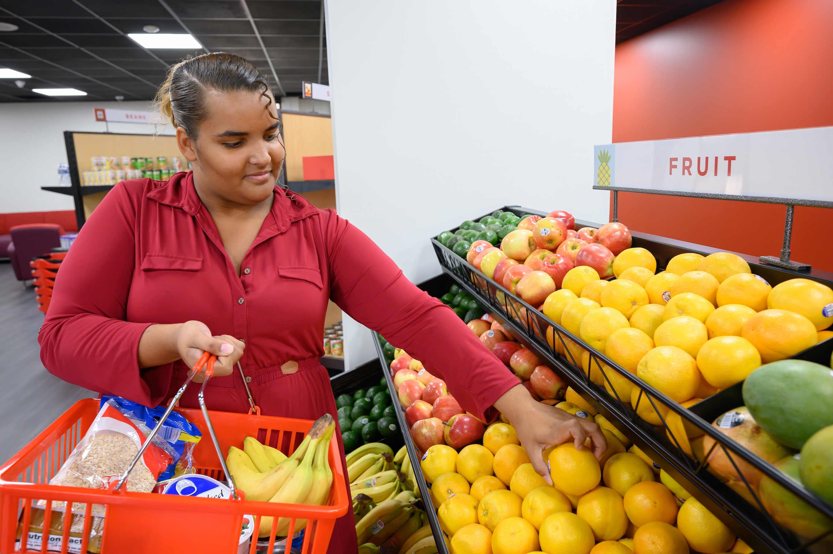 College student selects fresh fruit at Valencia College's new VCentials market.
